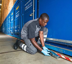 Exterminator setting trap in warehouse