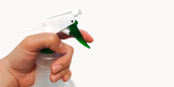 Hand holding a plastic spray bottle