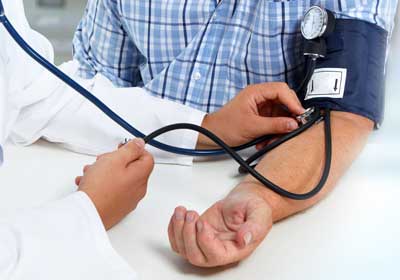 Doctor administering blood pressure test to patient 