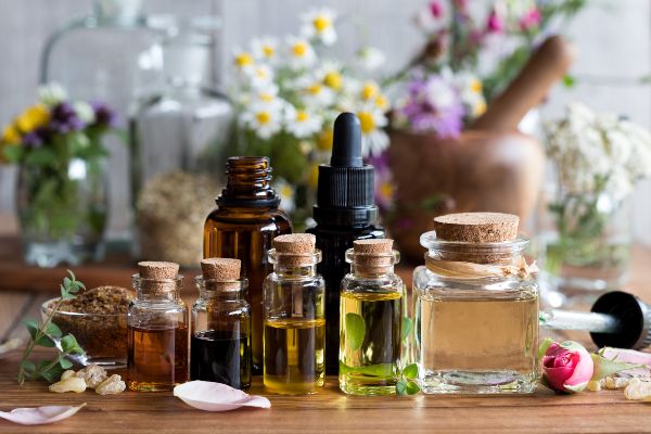 Bottles of essential oil with herbs in background