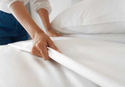Hands making white bedding