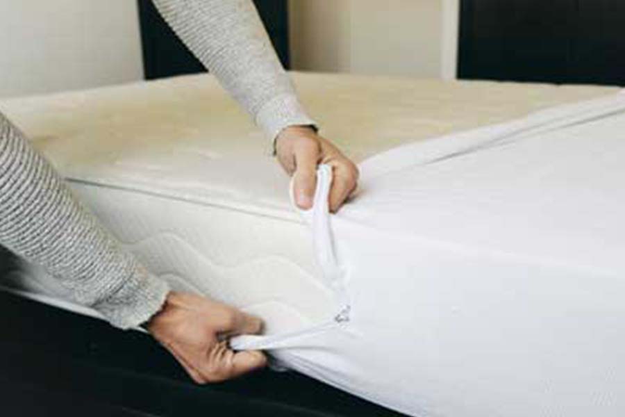 Hands pulling on mattress cover