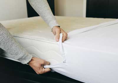 Hands pulling on mattress cover