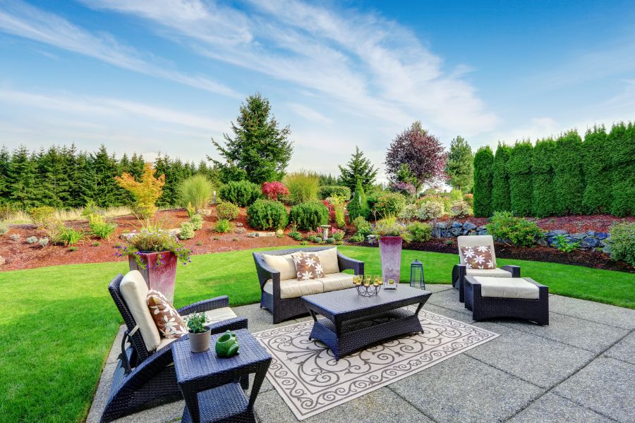 Patio furniture arranged in landscaped yard