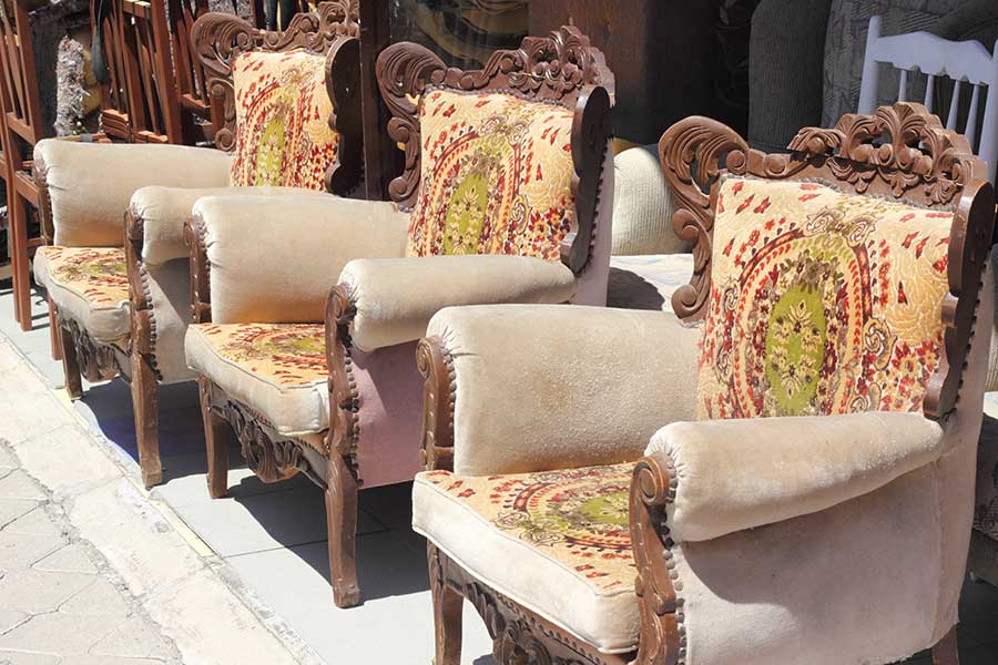 Used armchairs arranged in a line outside