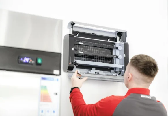 Professional technician installing a Lumnia UV fly trap inside a commercial business.