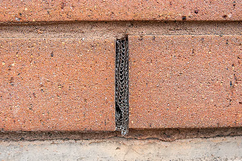 Flexi Armour mesh being used by Suburban Exterminating to seal the gap space between bricks of a brick wall.